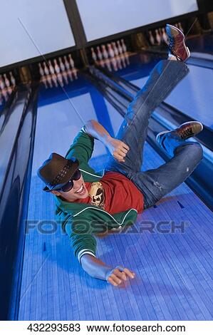 High angle view of a young man sliding in a bowling alley View Large Photo Image Stock Image - High angle view of a young man sliding in a bowling alley. Fotosearch