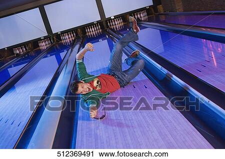 High angle view of a young man sliding in a bowling alley View Large Photo Image Stock Image - High angle view of a young man sliding in a bowling alley. Fotosearch
