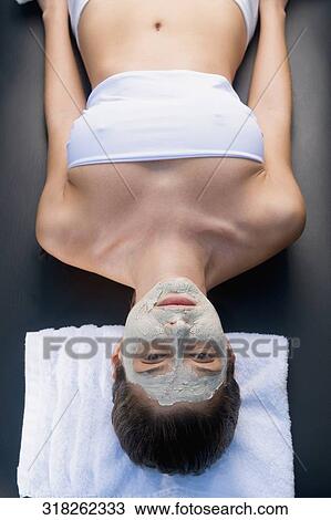 High angle view of a young woman lying on a massage table with facial mask View Large Photo Image Stock Image - High angle view of a young woman lying on a massage table with facial mask. Fotosearch