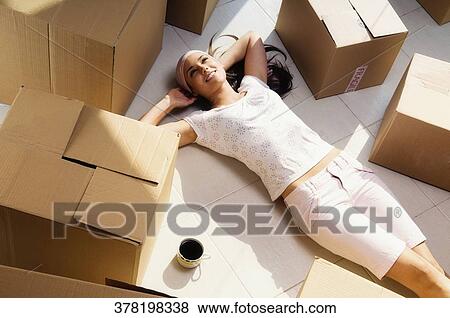 Stock Photo - High angle view of a young woman lying on the floor and smiling. Fotosearch