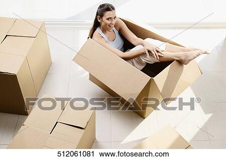 High angle view of a young woman laughing in a cardboard box View Large Photo Image Stock Image - High angle view of a young woman laughing in a cardboard box. Fotosearch