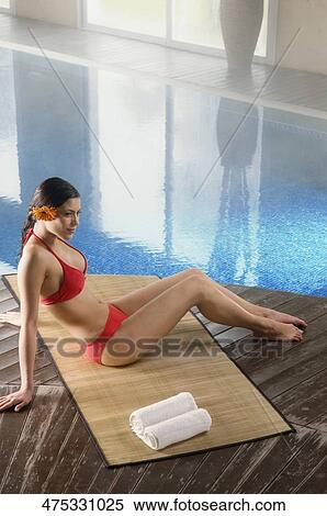High angle view of a young woman sitting at the poolside View Large Photo Image Stock Photography - High angle view of a young woman sitting at the poolside. Fotosearch