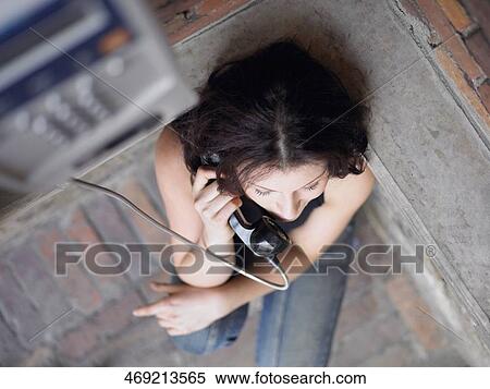 High angle view of a young woman using a pay phone View Large Photo Image Stock Photography - High angle view of a young woman using a pay phone. Fotosearch