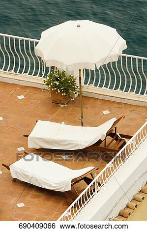 High angle view of empty lounge chairs with a patio umbrella, Positano, Amalfi Coast, Salerno, Campania, Italy View Large Photo Image Stock Photograph - High angle view of empty lounge chairs with a patio umbrella, Positano, Amalfi Coast, Salerno, Campania, Italy. Fotosearch