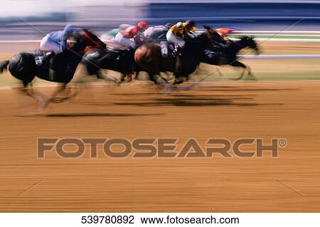 Jockeys riding their horses on a running track View Large Photo Image Stock Image - Jockeys riding their horses on a running track. Fotosearch