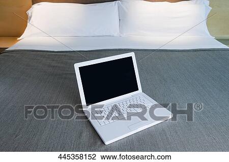 Laptop on the bed in a hotel room View Large Photo Image Stock Image - Laptop on the bed in a hotel room. Fotosearch
