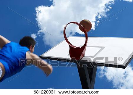 Low angle view of a basketball player shooting a goal View Large Photo Image Stock Image - Low angle view of a basketball player shooting a goal. Fotosearch