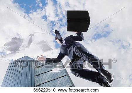 Low angle view of a businessman jumping in air View Large Photo Image Stock Image - Low angle view of a businessman jumping in air. Fotosearch