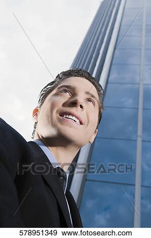 Stock Photo - Low angle view of a businessman smiling. Fotosearch