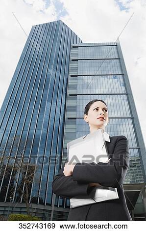 Low angle view of a businesswoman holding files View Large Photo Image Stock Photo - Low angle view of a businesswoman holding files. Fotosearch