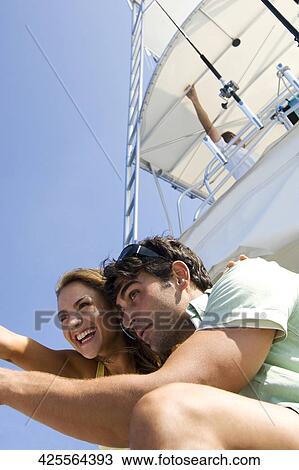 Low angle view of a couple standing on the ship View Large Photo Image Stock Image - Low angle view of a couple standing on the ship. Fotosearch