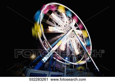Stock Image - Low angle view of a ferris wheel in an amusement park. Fotosearch