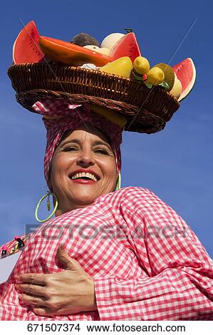 Picture - Low angle view of a mature woman selling fruits. Fotosearch