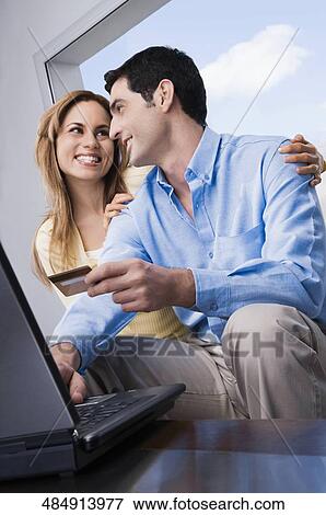 Low angle view of a mid adult couple shopping online View Large Photo Image Stock Photo - Low angle view of a mid adult couple shopping online. Fotosearch