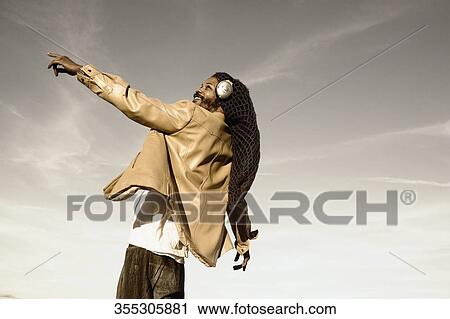 Low angle view of a mid adult man listening to music and dancing View Large Photo Image Stock Image - Low angle view of a mid adult man listening to music and dancing. Fotosearch