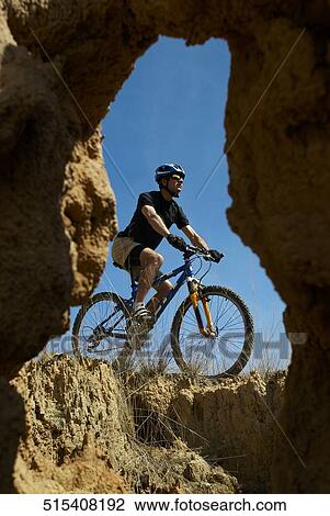 Low angle view of a mid adult man mountain biking View Large Photo Image Stock Image - Low angle view of a mid adult man mountain biking. Fotosearch