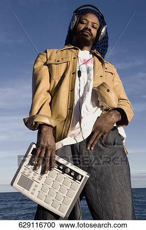 Low angle view of a mid adult man listening to music View Large Photo Image Stock Image - Low angle view of a mid adult man listening to music. Fotosearch
