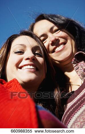 Stock Photography - Low angle view of a mother and daughter smiling. Fotosearch