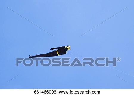 Stock Photograph - Low angle view of a person flying in the sky, Miami Beach, Florida, USA. Fotosearch