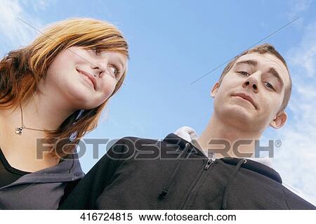 Low angle view of a young couple smiling View Large Photo Image Stock Photography - Low angle view of a young couple smiling. Fotosearch