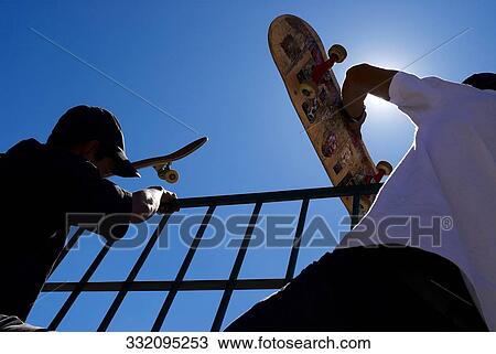 Low angle view of a young man and a mid adult man climbing a railing View Large Photo Image Stock Image - Low angle view of a young man and a mid adult man climbing a railing. Fotosearch