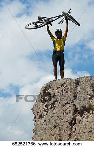 Low angle view of a young man carrying a mountain bike View Large Photo Image Stock Photograph - Low angle view of a young man carrying a mountain bike. Fotosearch