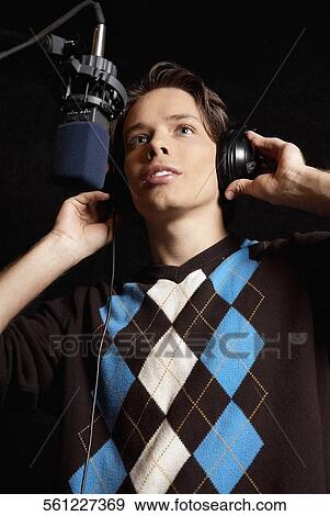Low angle view of a young man singing View Large Photo Image Stock Photo - Low angle view of a young man singing. Fotosearch