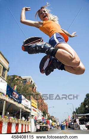Low angle view of a young woman jumping View Large Photo Image Stock Photography - Low angle view of a young woman jumping. Fotosearch