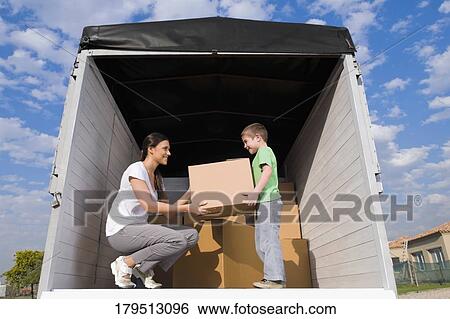 Low angle view of a young woman with her son carrying cardboard boxes View Large Photo Image Stock Photograph - Low angle view of a young woman with her son carrying cardboard boxes. Fotosearch