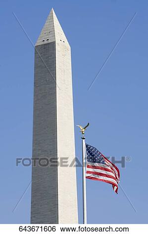 Stock Photograph - Low angle view of an American flag in front of an obelisk, Washington Monument, Washington DC, USA. Fotosearch
