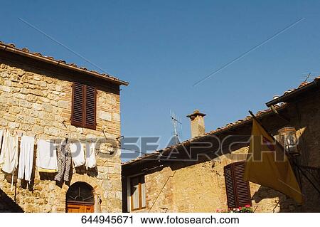 Low angle view of clothes drying in front of a house, San Gimignano, Siena Province, Tuscany, Italy View Large Photo Image Stock Image - Low angle view of clothes drying in front of a house, San Gimignano, Siena Province, Tuscany, Italy. Fotosearch
