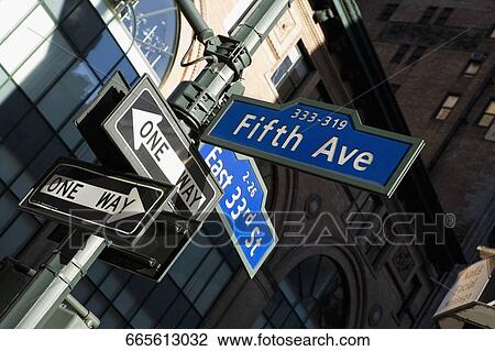 Stock Image - Low angle view of street name signs on a pole, Fifth Avenue, Manhattan, New York City, New York State, USA. Fotosearch