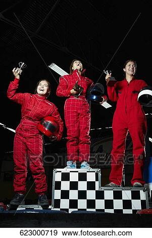 Low angle view of three female go-cart racers standing on winners podium with their trophies View Large Photo Image Stock Photo - Low angle view of three female go-cart racers standing on winners podium with their trophies. Fotosearch