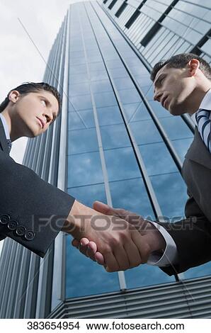 Low angle view of two businessmen shaking hands View Large Photo Image Picture - Low angle view of two businessmen shaking hands. Fotosearch