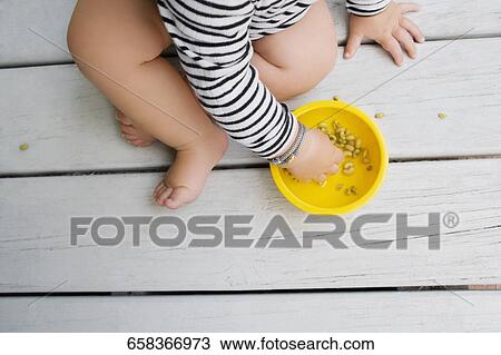 Low section view of a baby girl eating cereal View Large Photo Image Stock Image - Low section view of a baby girl eating cereal. Fotosearch