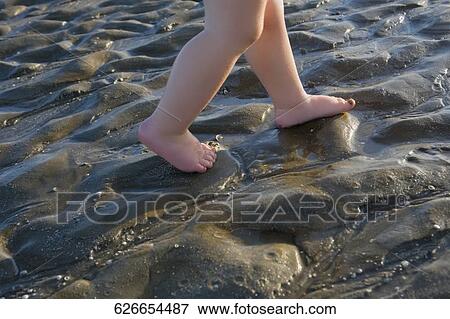 Low section view of a baby walking on mud View Large Photo Image Stock Photo - Low section view of a baby walking on mud. Fotosearch
