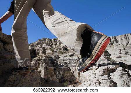 Low section view of a hiker walking on a rock View Large Photo Image Stock Image - Low section view of a hiker walking on a rock. Fotosearch