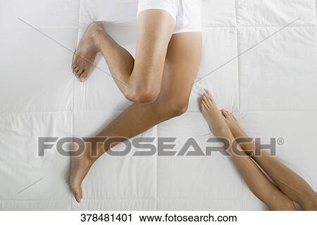 Low section view of a man and a woman lying on the bed View Large Photo Image Stock Image - Low section view of a man and a woman lying on the bed. Fotosearch