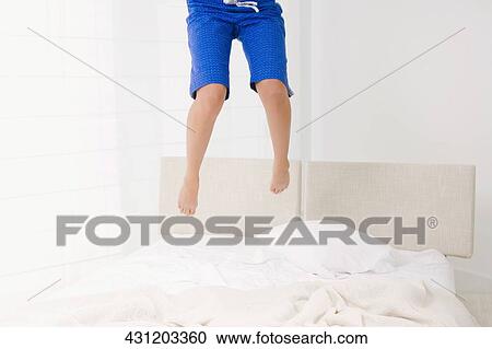 Low section view of a person jumping on the bed View Large Photo Image Stock Image - Low section view of a person jumping on the bed. Fotosearch