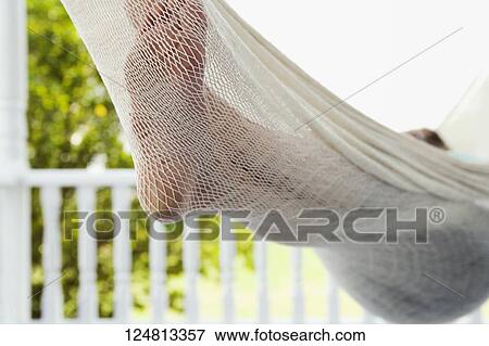 Stock Photo - Low section view of a person lying in a hammock. Fotosearch