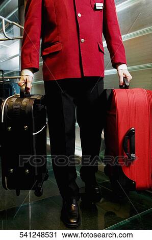 Low section view of a waiter carrying luggage View Large Photo Image Stock Image - Low section view of a waiter carrying luggage. Fotosearch