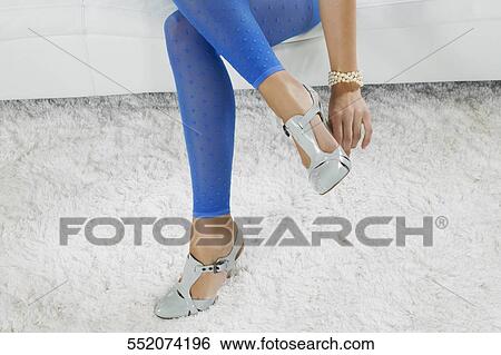 Low section view of a woman adjusting her high heels View Large Photo Image Stock Photograph - Low section view of a woman adjusting her high heels. Fotosearch