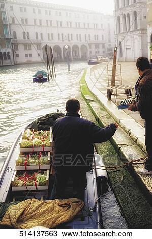 Man giving a packet to another man standing on a boat View Large Photo Image Stock Image - Man giving a packet to another man standing on a boat. Fotosearch