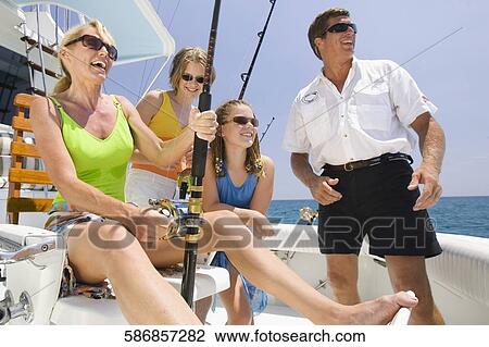 Stock Image - Mature couple fishing with their children. Fotosearch