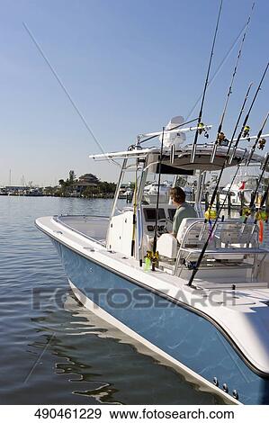 Mature man on a speedboat View Large Photo Image Stock Photo - Mature man on a speedboat. Fotosearch