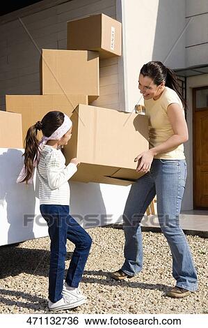Mature woman and her daughter carrying a cardboard box View Large Photo Image Stock Photograph - Mature woman and her daughter carrying a cardboard box. Fotosearch