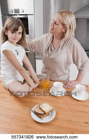 Stock Photograph - Mature woman having breakfast with her grandmother. Fotosearch