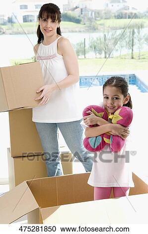 Mature woman holding a cardboard box with her daughter smiling View Large Photo Image Stock Image - Mature woman holding a cardboard box with her daughter smiling. Fotosearch