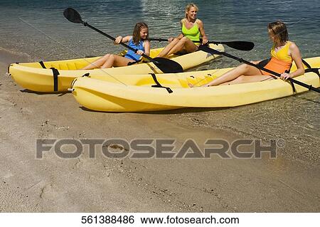 Stock Photograph - Mature woman with her daughters sitting in kayaks. Fotosearch