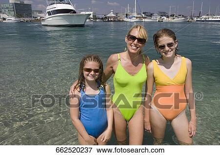 Mature woman with her daughters standing in the sea and smiling View Large Photo Image Stock Photo - Mature woman with her daughters standing in the sea and smiling. Fotosearch